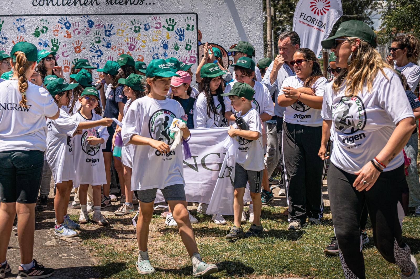 Young participants gathered in front of the painted handprints mural at the starting point of the plogging activity in Florida