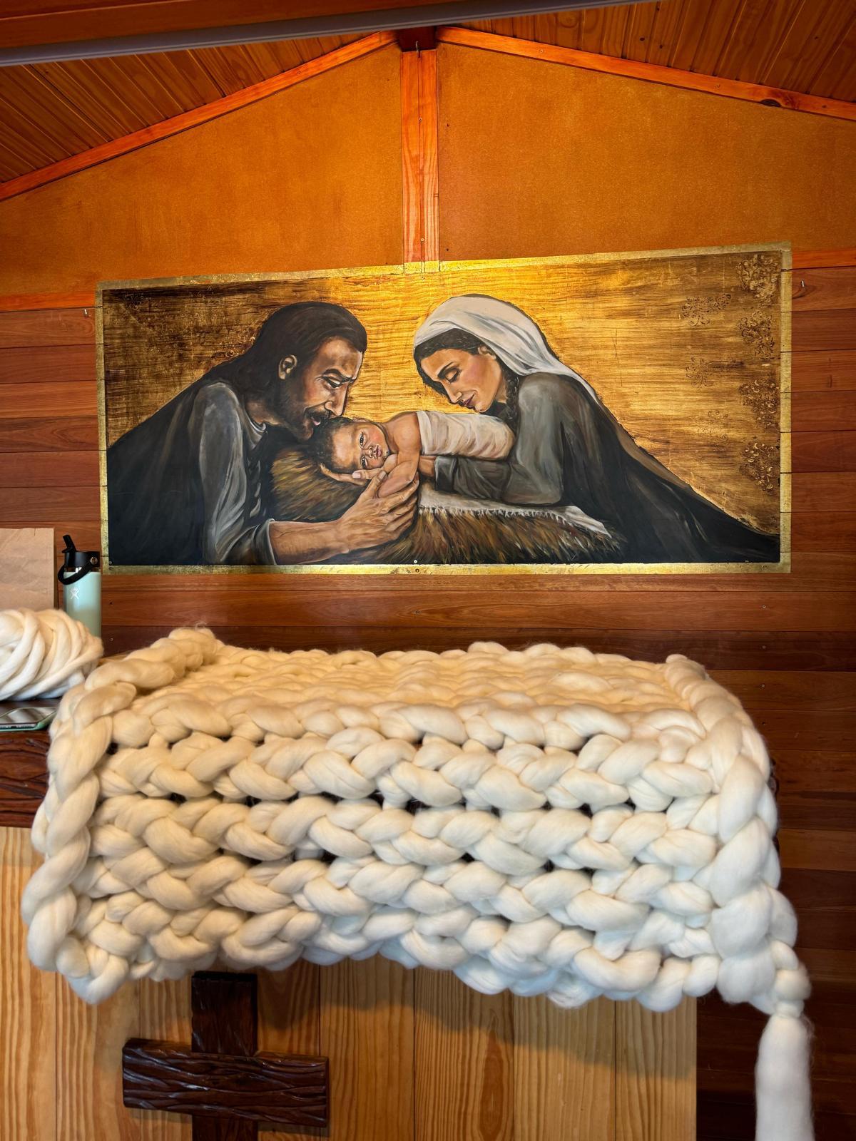 An XXL hand-knitted blanket created during the SUYAI workshops, displayed in the workshop space